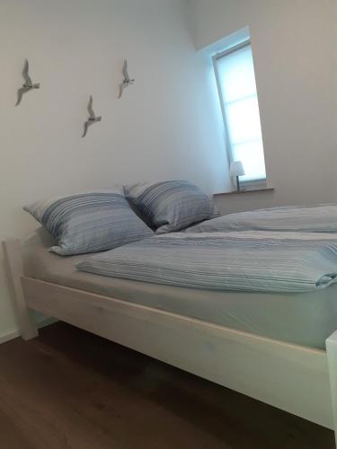 a bed with two pillows on it in a room at Echt Ostfriesenhus in Norden