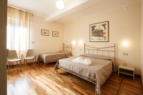 1 Schlafzimmer mit 2 Betten, einem Tisch und Stühlen in der Unterkunft A CASA DI LEO in Ascoli Piceno