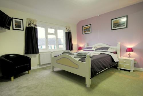 a bedroom with a white bed and a chair at The East Wing @ Lower Broom Farm in Kilgetty