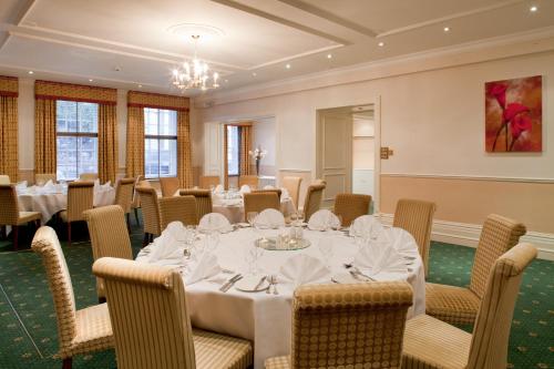 a dining room with a table and chairs at Mercure Salisbury White Hart Hotel & Apartments in Salisbury