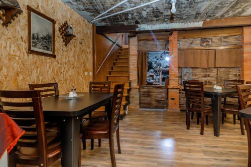 a dining room with tables and chairs and stairs at Borjomi Villa Roma in Borjomi