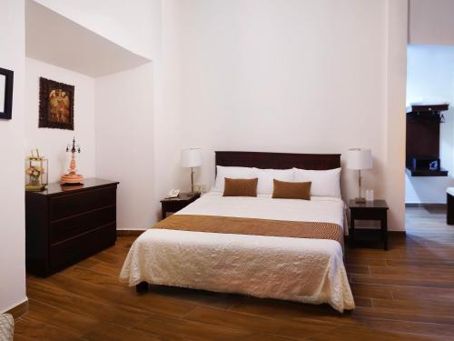 a bedroom with a large bed and two night stands at Hotel Casa Faroles Centro Histórico in Zacatecas