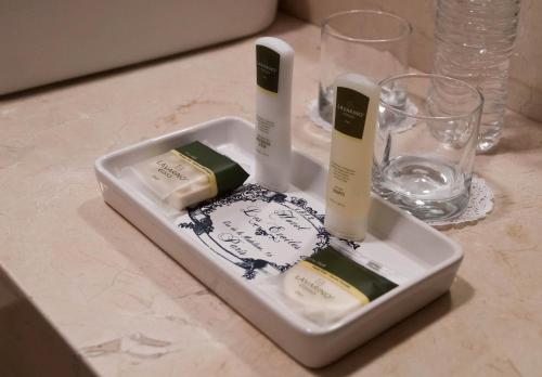 a white tray with two bottles of soap and wine glasses at Hotel Casa Faroles Centro Histórico in Zacatecas