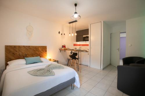 une chambre avec un grand lit et une cuisine dans l'établissement Le cocon d'Angela - Périgueux - Parking privé, à Périgueux