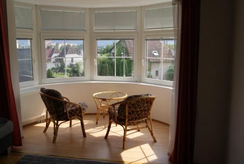 einen Tisch und Stühle in einem Zimmer mit Fenstern in der Unterkunft Apartmán Český ráj in Turnov