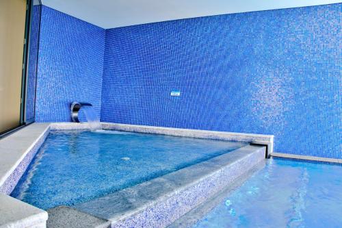 a large swimming pool with a blue tile wall at Villa Ria Alvor- Swimming pool & Jacuzzi in Mexilhoeira Grande