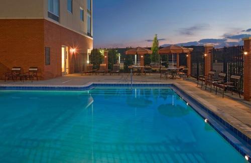 a large blue swimming pool next to a building at Hyatt Place Nashville Airport in Nashville