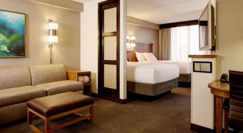 Habitación de hotel con dormitorio con cama y sofá en Hyatt Place Nashville Airport en Nashville