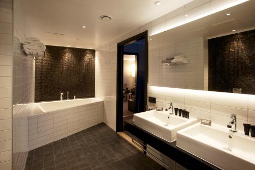 baño con 2 lavabos y espejo grande en Clarion Hotel Sense en Luleå