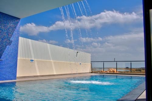 a swimming pool with water shooting up into the air at Villa Ria Alvor- Swimming pool & Jacuzzi in Mexilhoeira Grande