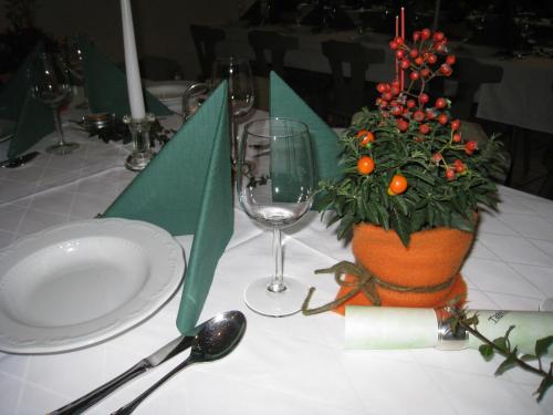 a table with a plate and a plant and a glass at Gasthof zum Mohrn in Oberwölz Stadt