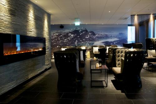 a restaurant with chairs and a wall with a fireplace at Clarion Hotel Sense in Luleå