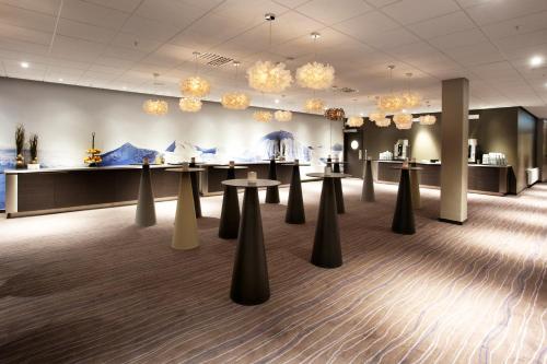 a waiting room with tables and chandeliers at Clarion Hotel Sense in Luleå