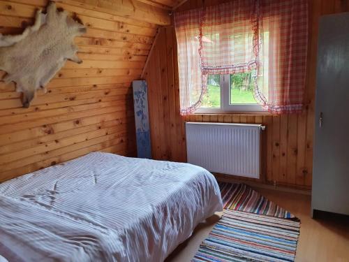 a bedroom with a bed and a wooden wall at Casa Dor de Ea in Dâmbovicioara