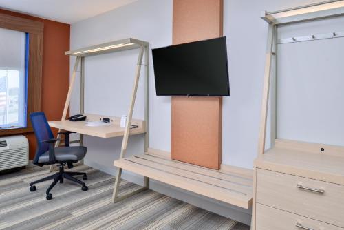 an office cubicle with a desk and a tv at Holiday Inn Express & Suites - Southgate - Detroit Area by IHG in Southgate