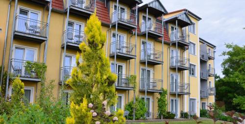 an apartment building with balconies and a tree at Hotel Bergwirt in Herrieden