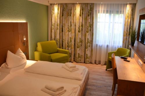 a hotel room with a bed and a chair at Hotel Bergwirt in Herrieden