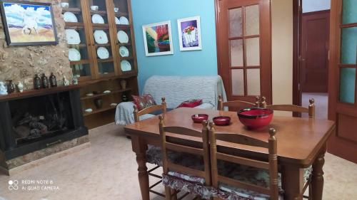 a dining room with a table and a fireplace at Casa Rural El Cerrete 2 in Riópar