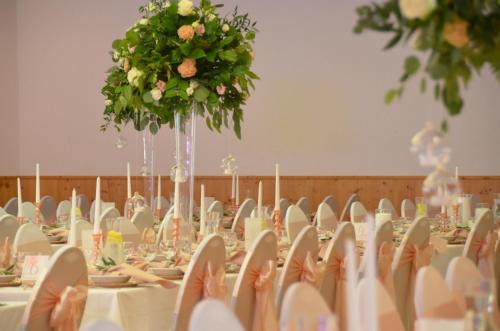 a banquet hall with white tables and chairs and flowers at Hotel Bergwirt in Herrieden