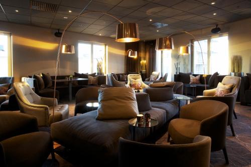 a waiting room with couches and chairs and windows at Clarion Hotel Sense in Luleå