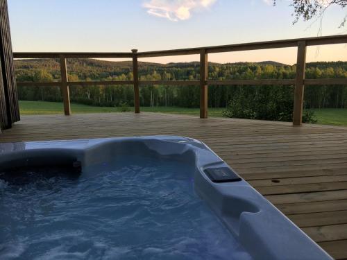 a jacuzzi tub on the deck of a house at Stilleben Hotell in Åmot