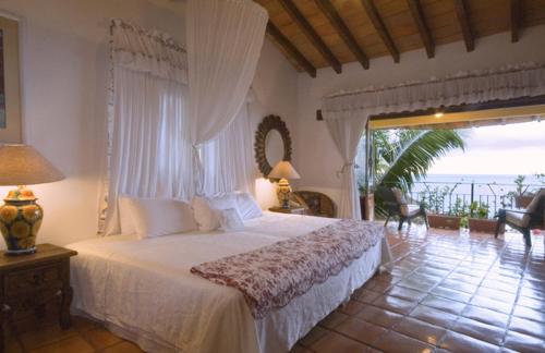 a bedroom with a bed with a view of the ocean at Casa Isabel a Boutique Hilltop Inn in Puerto Vallarta