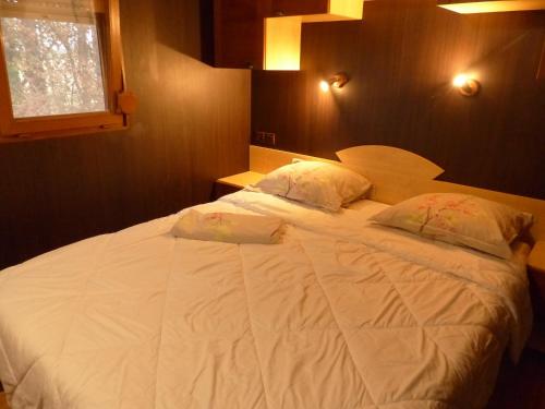 ein großes weißes Bett in einem Schlafzimmer mit Fenster in der Unterkunft La Maison Blanche in Courlans