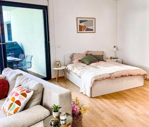 um quarto branco com uma cama e um sofá em Seaview Apt Koper 2 em Koper