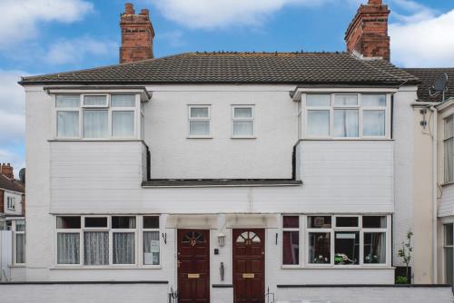 a white house with two chimneys at M and J Guest House in Cleethorpes