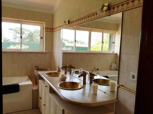 a bathroom with two sinks and a tub at Casa do Vale in Chelreira
