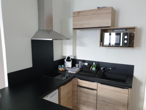 a kitchen with a sink and a microwave at Au 16 in Dijon