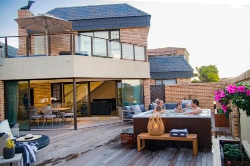 a house with two children in a hot tub on a deck at African Oceans Manor on the Beach in Mossel Bay