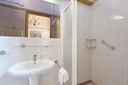 a white bathroom with a sink and a mirror at Hotel Pension 't Huys Grol in Renesse