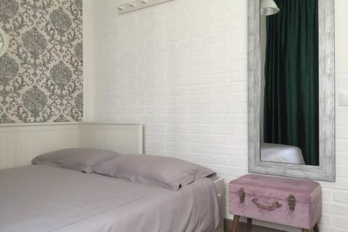 ein Schlafzimmer mit einem Bett mit einem Spiegel und einem rosa Koffer in der Unterkunft Cosy holiday apartment in Lagos in Lagos