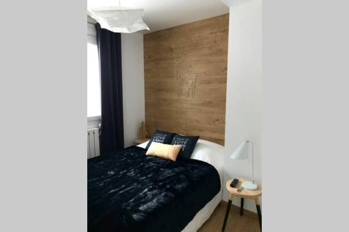 a bedroom with a bed and a wooden wall at Jaune Génépi in Valloire