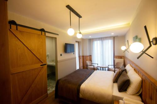 a hotel room with a large bed and a table at Ayder Koru Hotel in Ayder Yaylasi