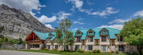 a large building with a view of a mountain range at Waterton Glacier Suites in Waterton Park