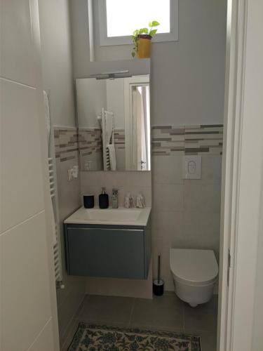 een badkamer met een wastafel, een toilet en een spiegel bij Terra di Sud Rooms in Lecce