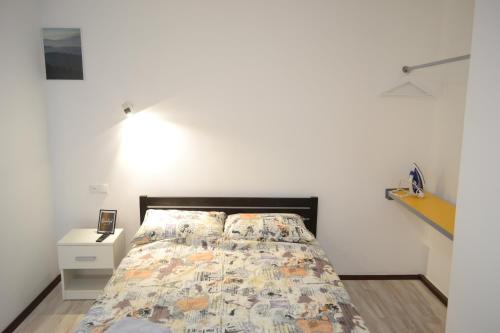 ein Schlafzimmer mit einem Bett und einer weißen Wand in der Unterkunft Smart in Ternopil