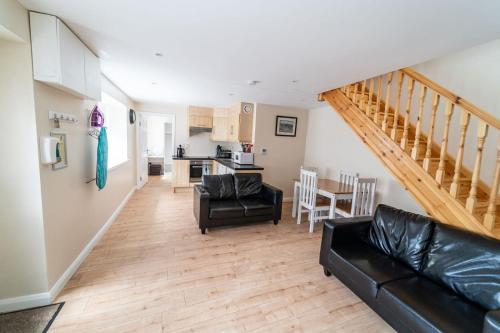 a living room with a couch and a kitchen at The Cosy Cottage in Moville