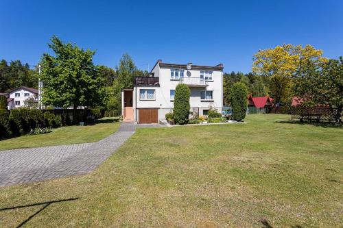 una casa con un gran patio delante de ella en Rybacka 48 - Twoje miejsce wypoczynku, domki, pokoje, apartamenty en Jantar