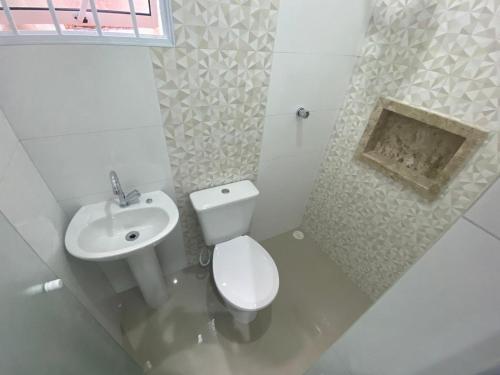 a white bathroom with a toilet and a sink at Hotel Quintino - Metrô Sé -localizado no coração de São Paulo Próximo 10 minutos do Brás 5 minutos da 25 de Março e com estacionamento no local grátis in Sao Paulo