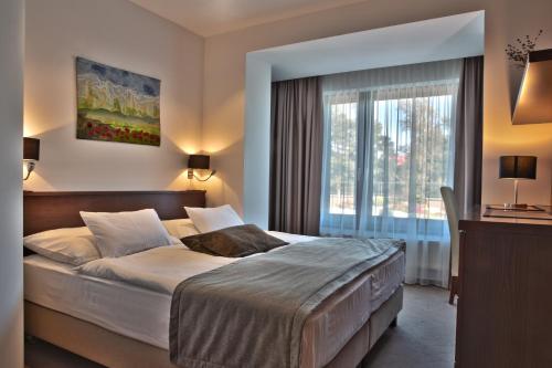 ein Schlafzimmer mit einem großen Bett und einem Fenster in der Unterkunft PRIVILEGED LESNÁ - with Garden Terrace, Tatranská Lomnica 2 km in Stará Lesná