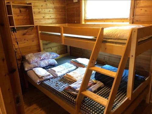 a bunk bed in a log cabin with towels at Kulpmo Gård Jarfjord-Kirkenes in Kirkenes
