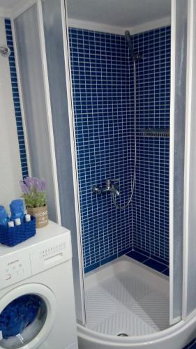 a shower in a bathroom with a washing machine at Above the Sea Apartment in Nea Kallikrateia