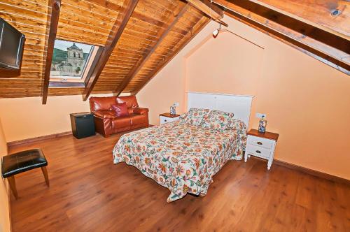 een slaapkamer met een bed en een stoel bij Hotel Rural Pajarapinta in Molinaseca