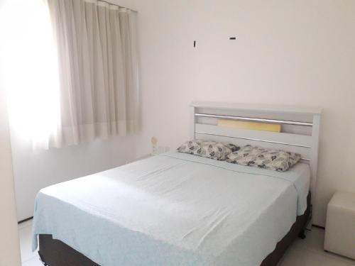a white bed in a white bedroom with a window at Villa Costeira Beira Mar in Fortaleza