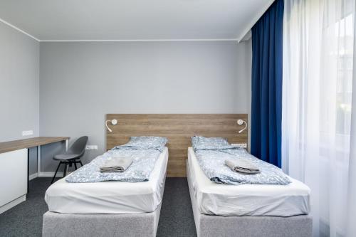 two twin beds in a room with a window at Hugo in Gdynia