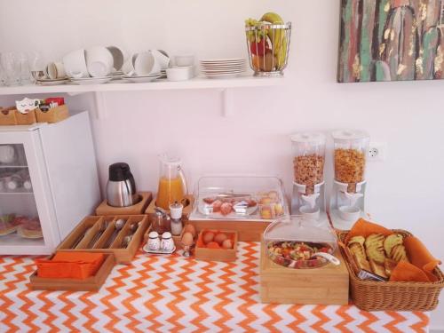 Bouganville Bed & Breakfast Stegna في أرخانجلوس: طاولة مع طعام وأصناف أخرى في المطبخ