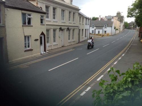 a person riding a motorcycle down a street at Reayrt Ny Marrey in Kirkmichael